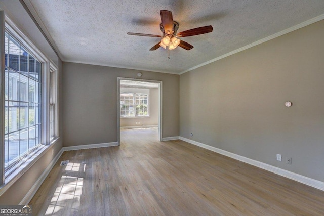 spare room with ceiling fan, light hardwood / wood-style floors, crown molding, and a textured ceiling