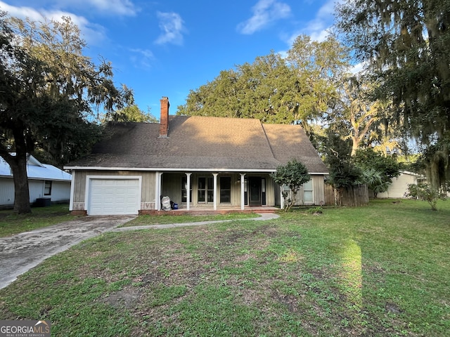 view of front of property featuring a garage, a front yard, and covered porch