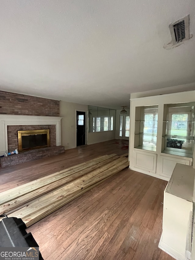 unfurnished living room featuring a fireplace and dark hardwood / wood-style floors