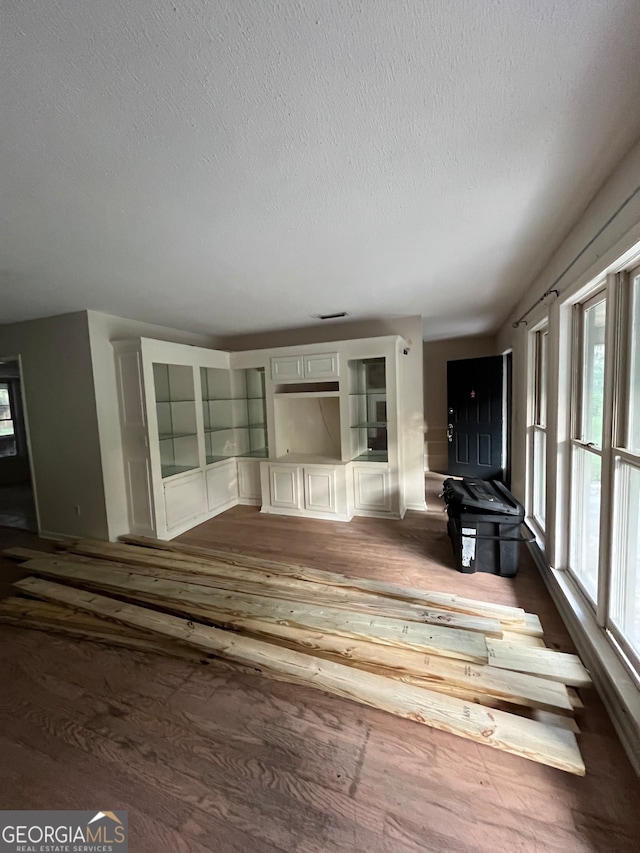 miscellaneous room featuring dark hardwood / wood-style floors and a textured ceiling