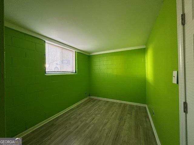 unfurnished room with wood-type flooring and ornamental molding