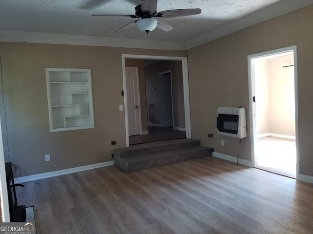 interior space with wood-type flooring, heating unit, a textured ceiling, and ceiling fan