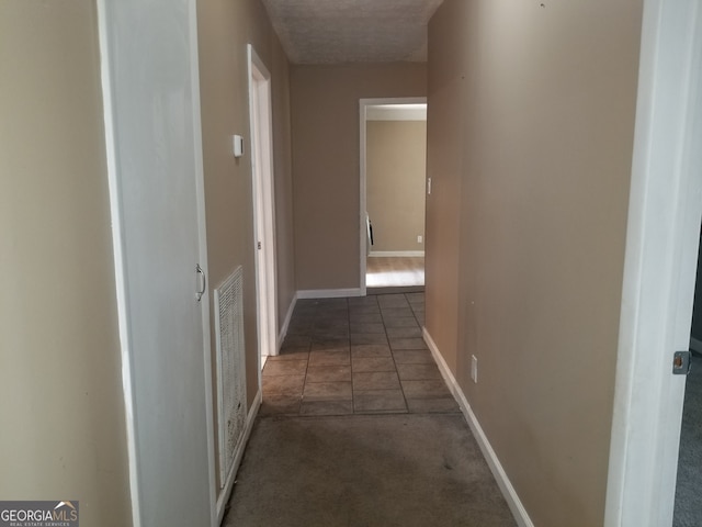 hall featuring dark tile patterned floors