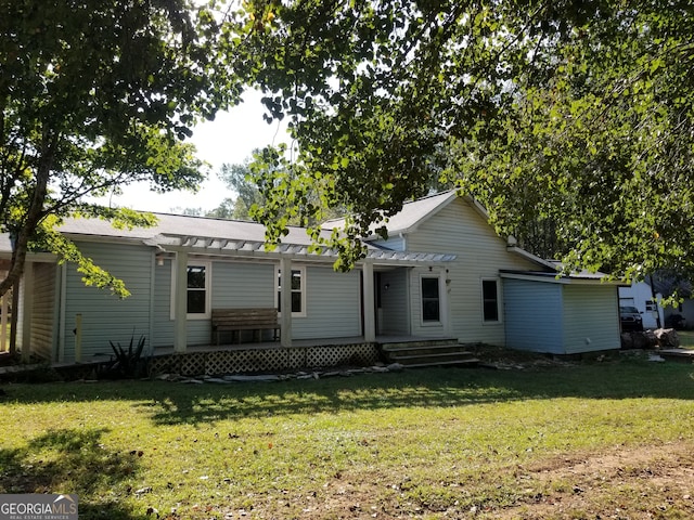 rear view of house featuring a yard