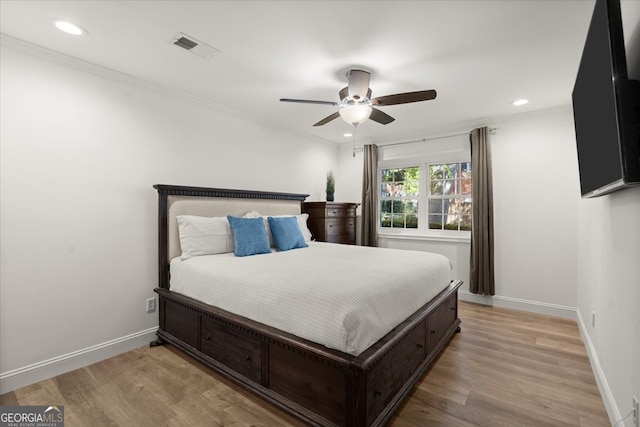 bedroom with ceiling fan, light wood-type flooring, and ornamental molding