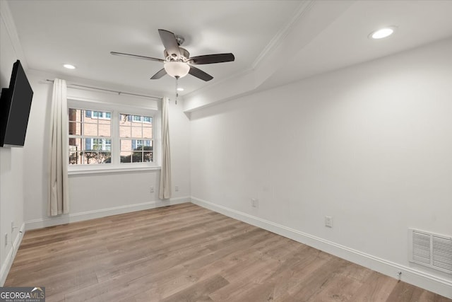 empty room featuring ornamental molding, light hardwood / wood-style flooring, and ceiling fan