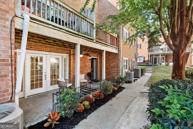 view of patio with a balcony, french doors, and central AC unit