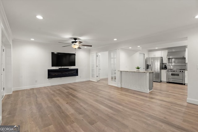 unfurnished living room with french doors, crown molding, light hardwood / wood-style flooring, and ceiling fan