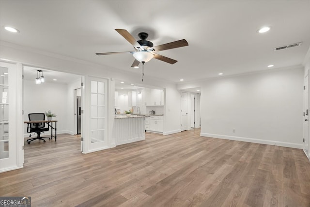 unfurnished living room featuring light hardwood / wood-style floors, ornamental molding, and ceiling fan