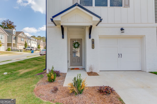 doorway to property featuring a lawn and a garage