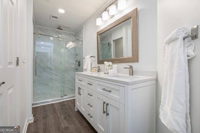 bathroom featuring vanity, ornamental molding, walk in shower, and wood-type flooring