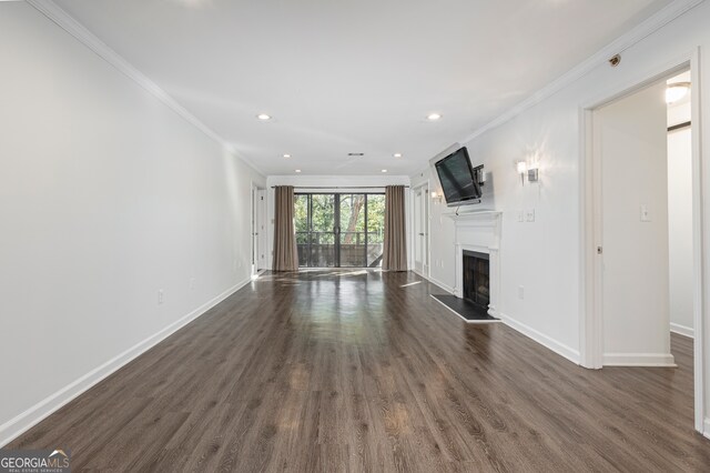 unfurnished living room with crown molding and dark hardwood / wood-style flooring