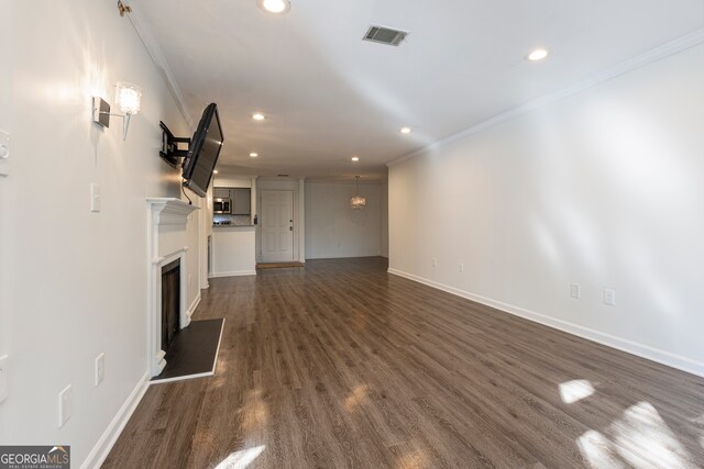 unfurnished living room with dark wood-type flooring and ornamental molding