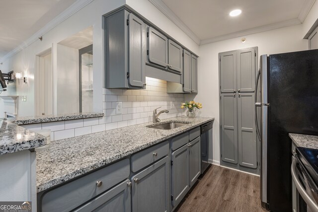 kitchen with ornamental molding, dark wood-type flooring, sink, gray cabinetry, and stainless steel appliances