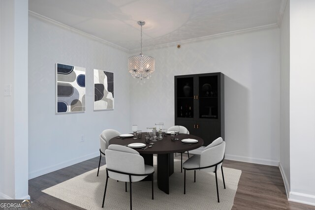 dining area featuring crown molding, a chandelier, and dark hardwood / wood-style flooring