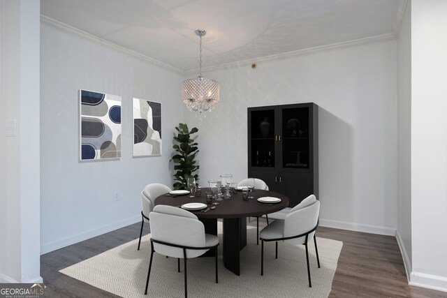 dining room with a notable chandelier, ornamental molding, and dark hardwood / wood-style flooring