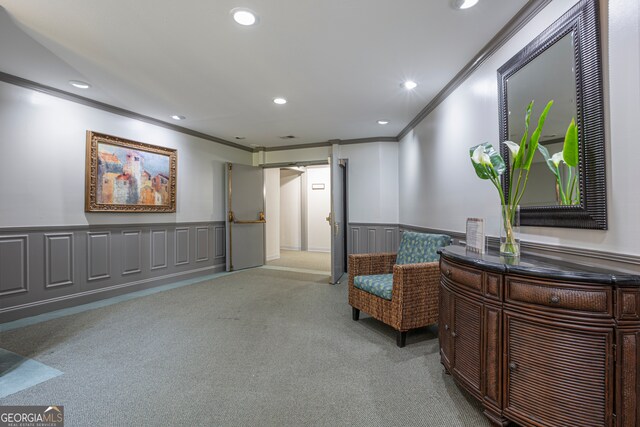 sitting room featuring ornamental molding and light colored carpet