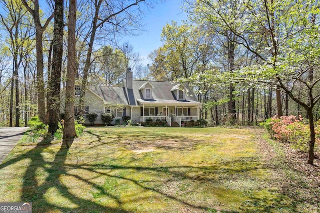 cape cod house with a front lawn and covered porch