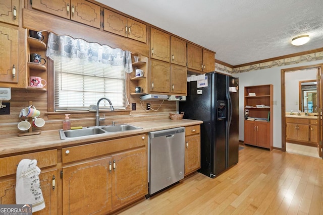 kitchen featuring light hardwood / wood-style floors, black fridge, sink, dishwasher, and a textured ceiling