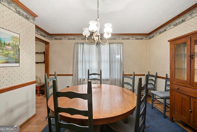 dining room with wood-type flooring, ornamental molding, and an inviting chandelier