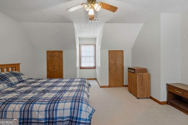 carpeted bedroom with ceiling fan, a textured ceiling, and lofted ceiling