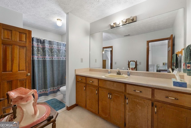 bathroom featuring vanity, toilet, a textured ceiling, and a shower with shower curtain