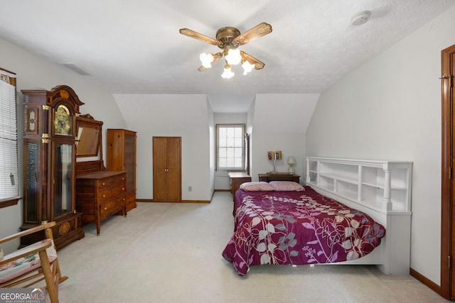 carpeted bedroom with ceiling fan, vaulted ceiling, and a textured ceiling