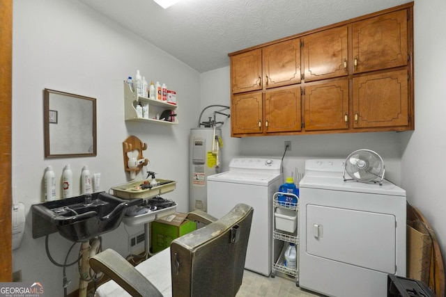 laundry area with electric water heater, cabinets, a textured ceiling, and washing machine and dryer