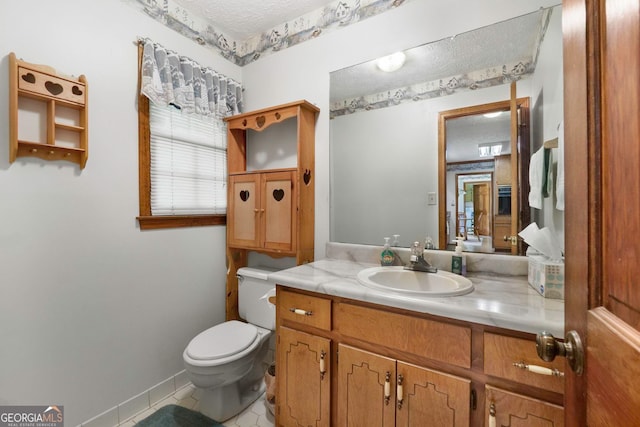 bathroom with a textured ceiling, tile patterned floors, vanity, and toilet