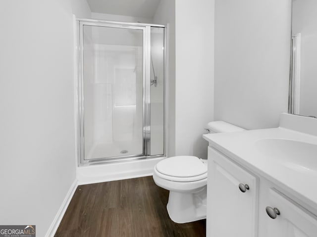 bathroom with an enclosed shower, wood-type flooring, vanity, and toilet