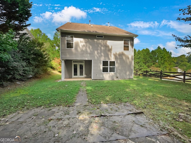 rear view of house with french doors and a yard