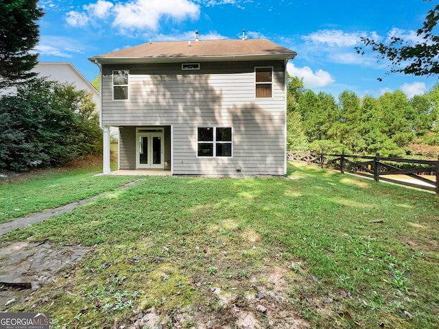 back of house featuring french doors and a lawn