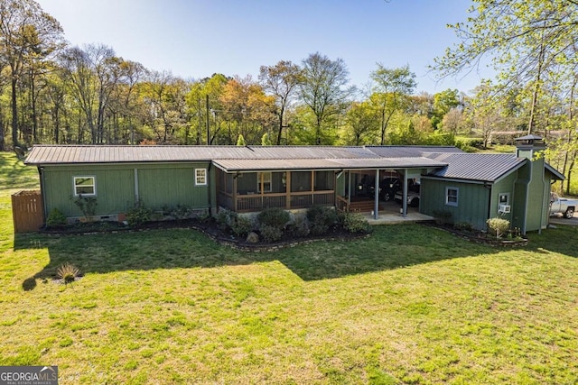 rear view of property featuring a lawn