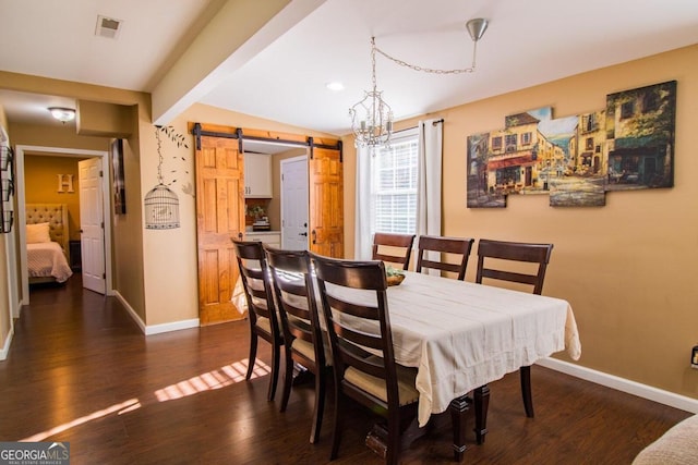 dining room with a barn door and dark hardwood / wood-style flooring