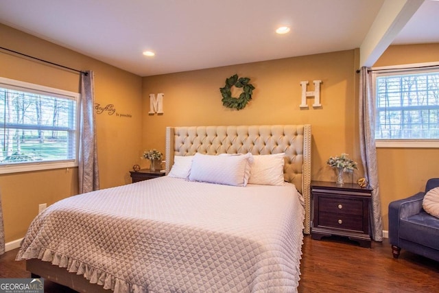 bedroom with dark wood-type flooring and multiple windows