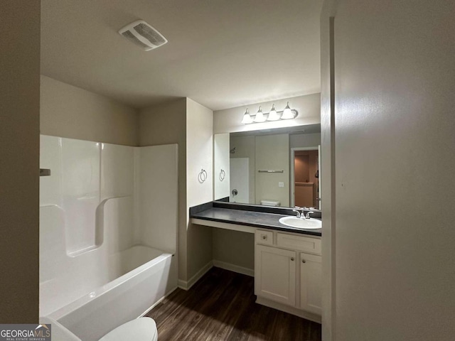 full bathroom with wood-type flooring, vanity, bathing tub / shower combination, and toilet