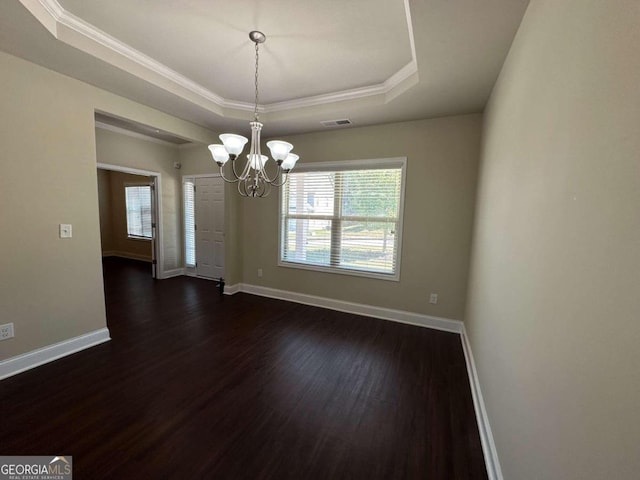 unfurnished dining area with a tray ceiling, dark hardwood / wood-style floors, and a healthy amount of sunlight