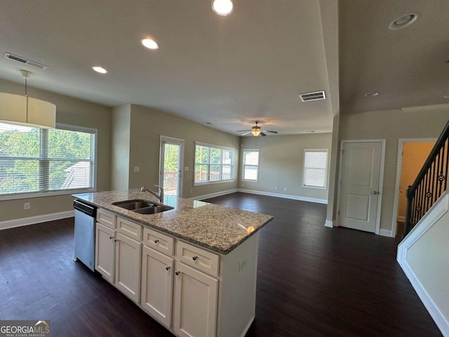 kitchen featuring a healthy amount of sunlight, sink, stainless steel dishwasher, and white cabinetry