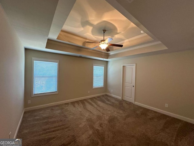 carpeted spare room featuring crown molding, ceiling fan, and a raised ceiling