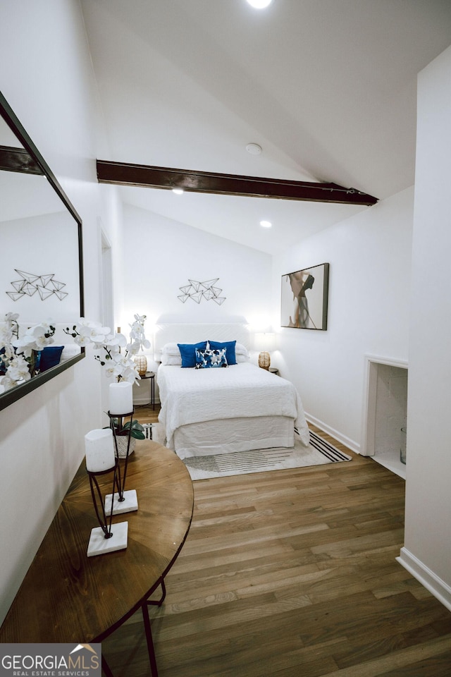 bedroom with dark hardwood / wood-style floors and vaulted ceiling with beams