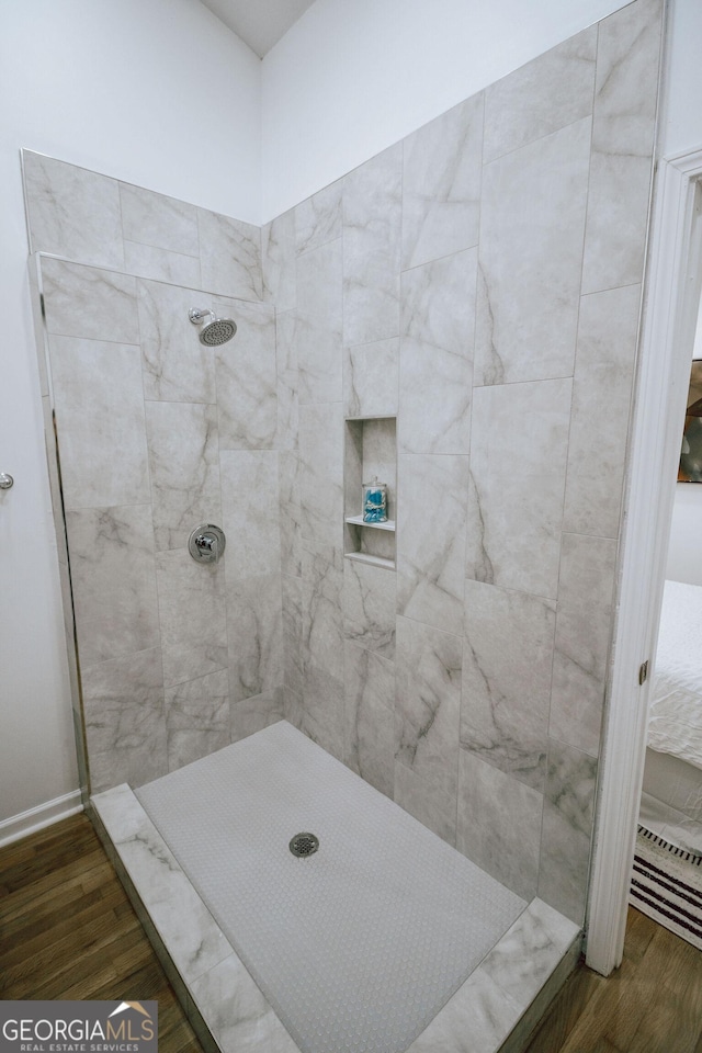 bathroom featuring hardwood / wood-style flooring and tiled shower