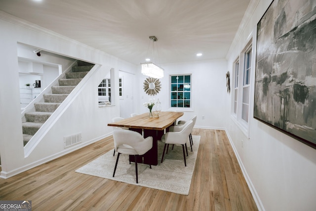 dining area featuring crown molding and light hardwood / wood-style flooring