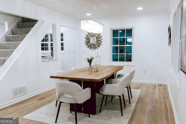 dining room with crown molding and light hardwood / wood-style floors