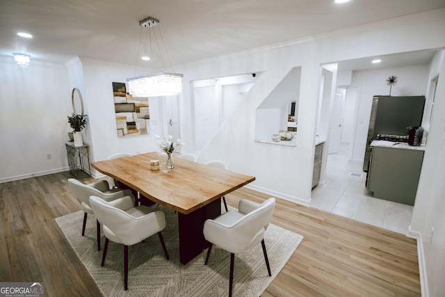 dining room with crown molding and light hardwood / wood-style flooring