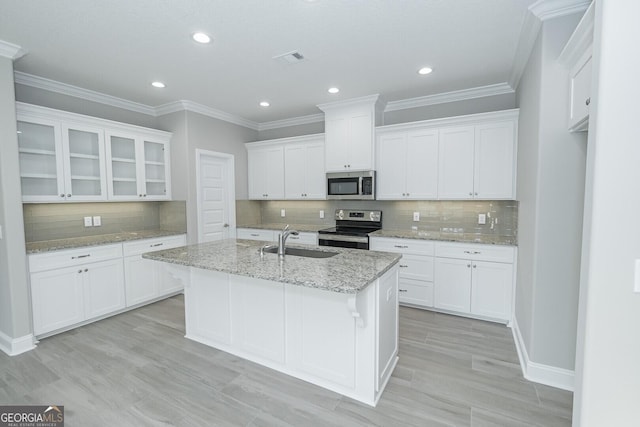 133 Amanda Trce, Kingsland, GA 31548 - kitchen featuring appliances with stainless steel finishes, white cabinetry, backsplash, a kitchen island with sink, and recessed lighting