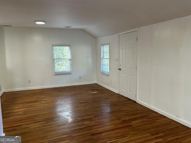 interior space featuring visible vents, baseboards, lofted ceiling, and wood finished floors