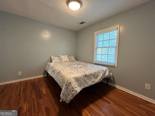 bedroom featuring visible vents, wood finished floors, and baseboards