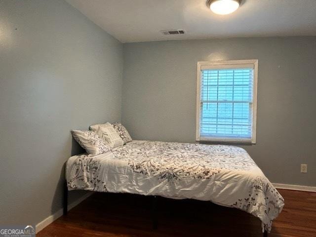 bedroom featuring dark wood-type flooring, baseboards, and visible vents