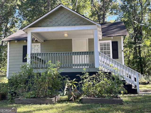 bungalow-style house with a porch, a garden, and stairway