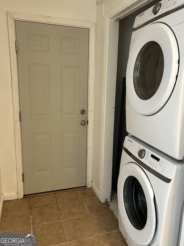 laundry area with stacked washer and dryer, laundry area, and tile patterned flooring